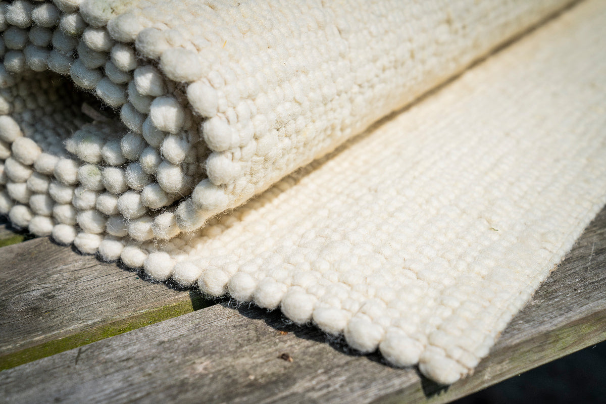 Close-up van Texelkleed Branding opgerold, gemaakt van witte Texelse schapenwol.