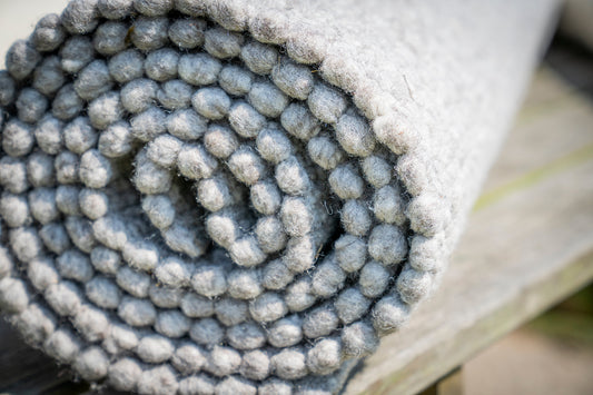 Close-up van Texelkleed Schelp opgerold, gemaakt van 80% witte en 20% blauwe Texelse schapenwol.