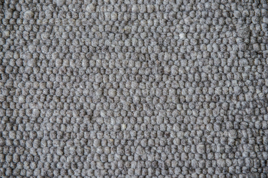 Close-up van Texelkleed Slufter, gemaakt van 50 % witte en 50% blauwe Texelse schapenwol. 