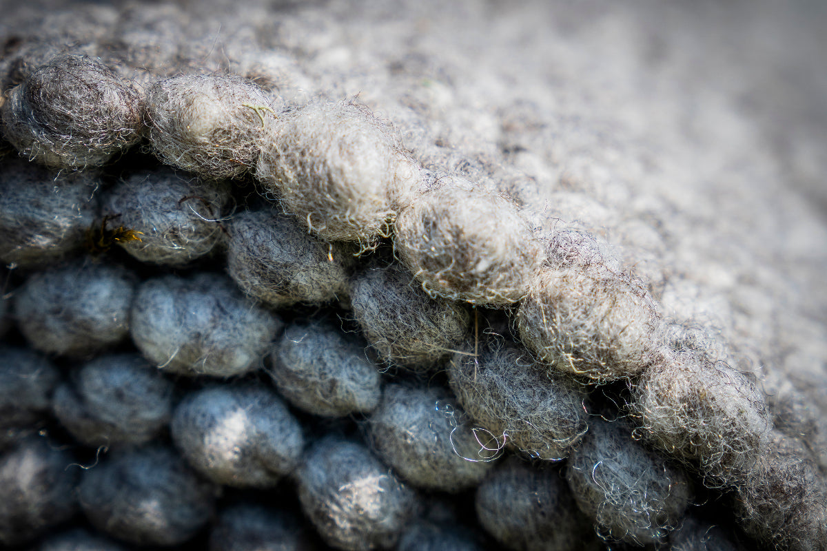 Close-up van Texelkleed Slufter opgerold, gemaakt van 50% witte en 50% blauwe Texelse schapenwol.